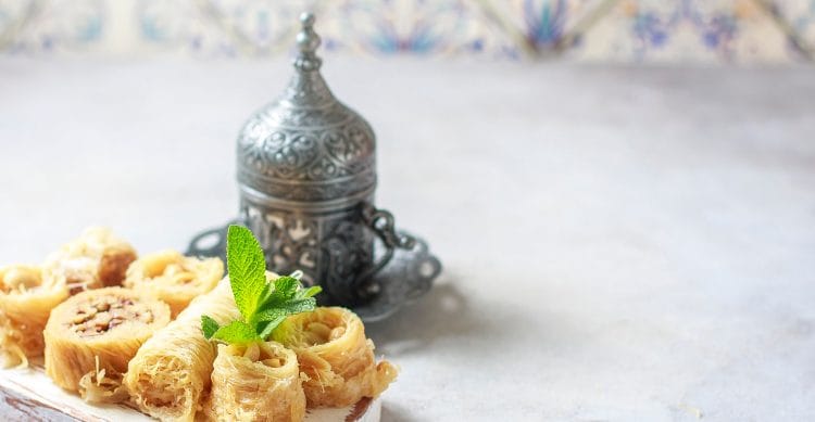 Baklava or baklawa. Ramadan Dessert. Traditional Arabic dessert with pistachios, honey and mint tea on dark surface, selective focus.