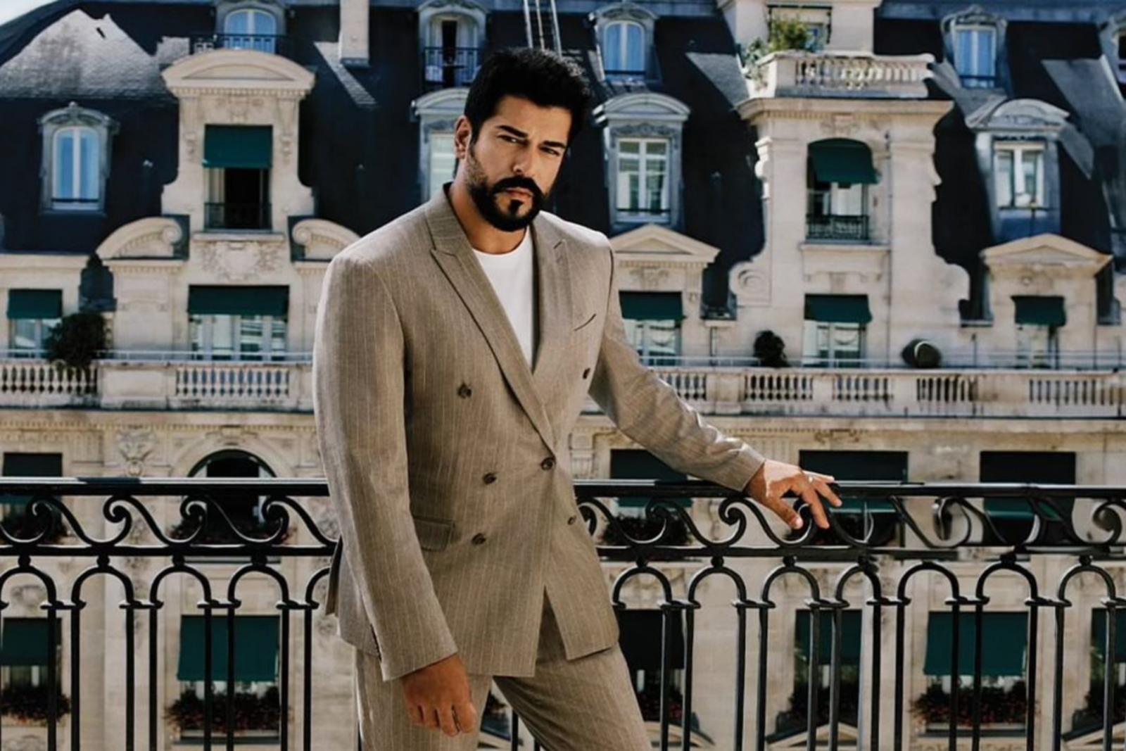 Burak Ozcivit poses in a stylish suit for a brand advertisement